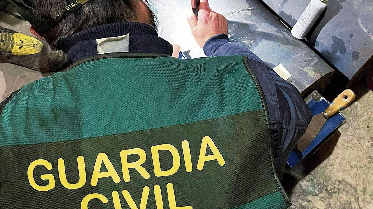 Imagen de archivo de un guardia civil examinando unos cilindros de una máquina donde se descubrió un alijo de cocaína.