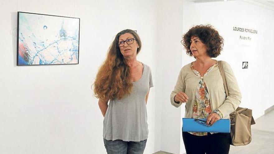 Lourdes Romaguera y la consellera, Pepita Prats, frente a una de las obras expuestas.