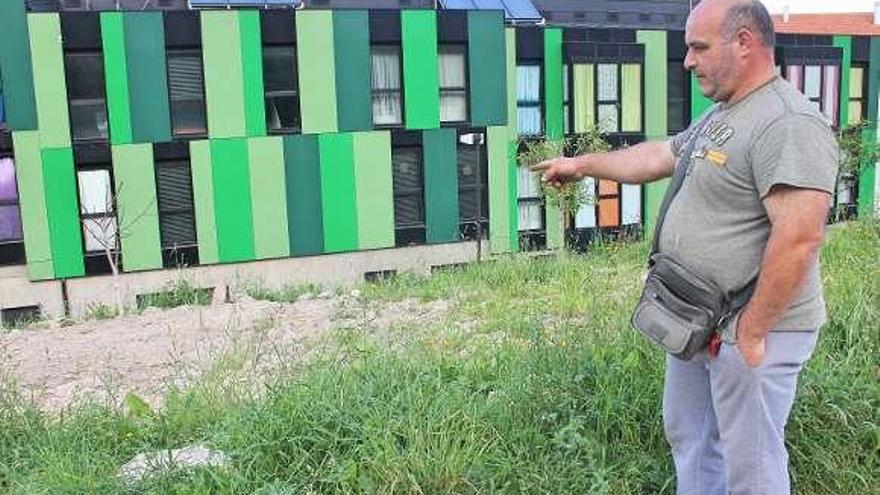 Un vecino muestra un huerto detrás de las viviendas de protección.