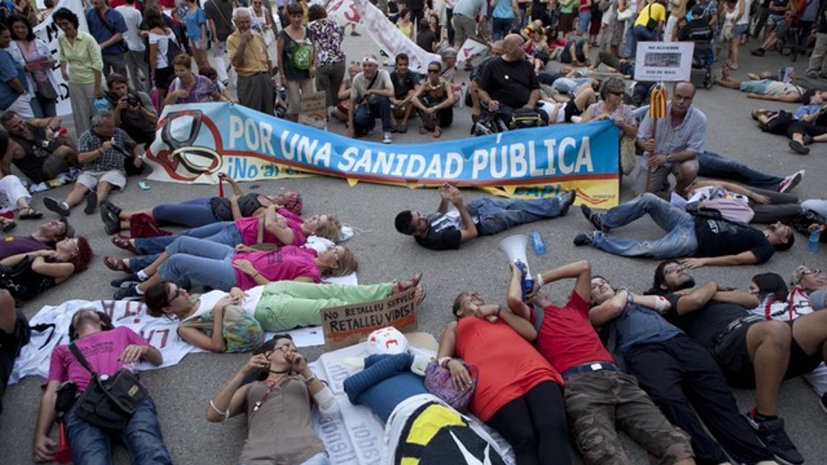 Manifestantes tumbados ante la entrada de la sede de la Conselleria de Salut, este viernes en Barcelona.