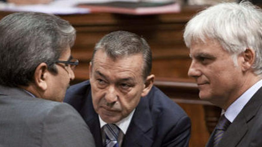 Román Rodríguez (de espaldas) habla con el presidente, Paulino Rivero, y el vicepresidente, José Miguel Pérez, antes del debate presupuestario, ayer.  i EFE
