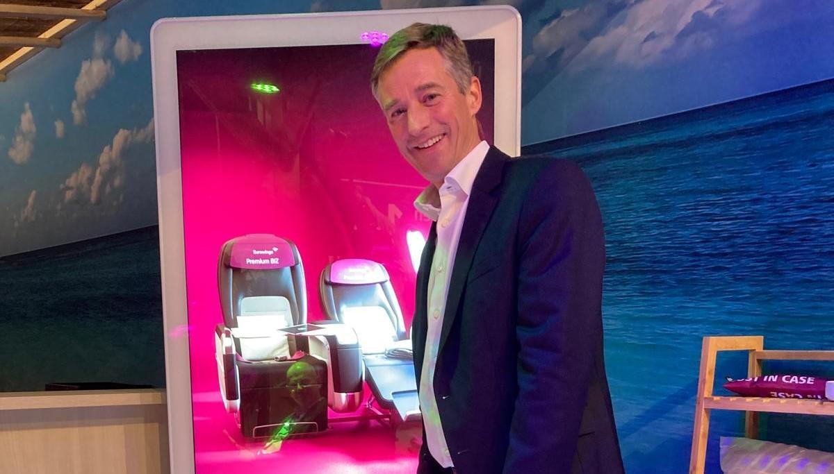 Max Kownatzki, der neue Eurowings-Chef, vor einem Bildschirm mit den Premium-Sitzen seiner Airline.