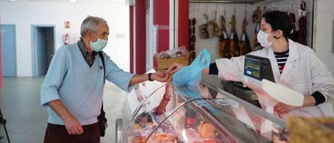 Cliente en una carnicería de la Praza de Abastos. // Bernabé