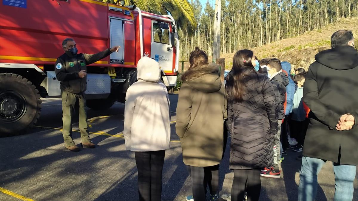 Uno de los agentes medioambientales explica a los alumnos el funcionamiento de una motobomba.