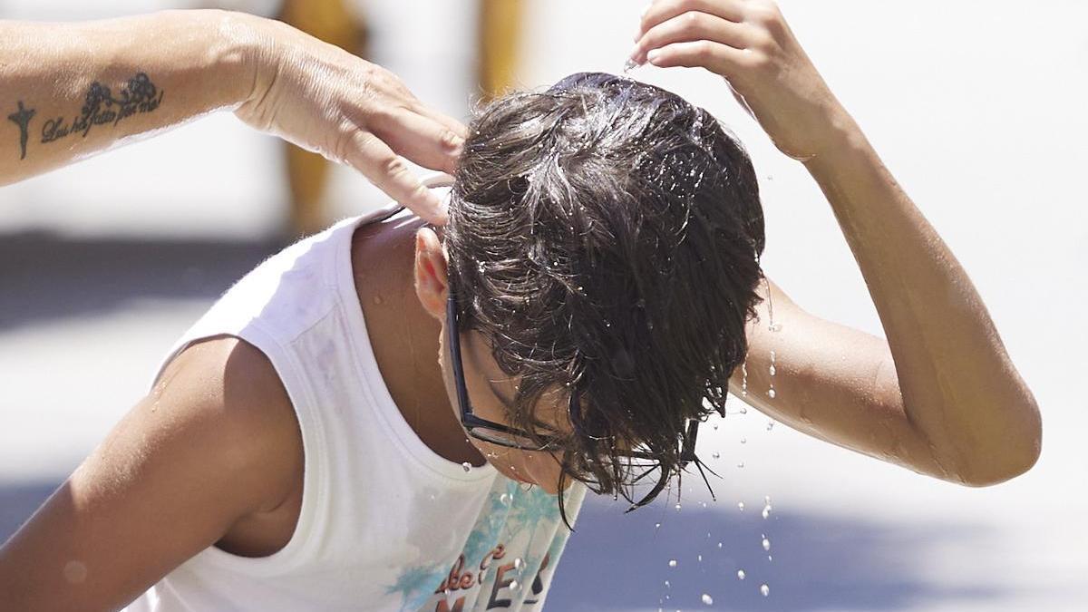 Un niño se echa agua por la cabeza para refrescarse en el primer día de la segunda ola de calor, a 7 de julio de 2022 en Sevilla (Andalucía, España)