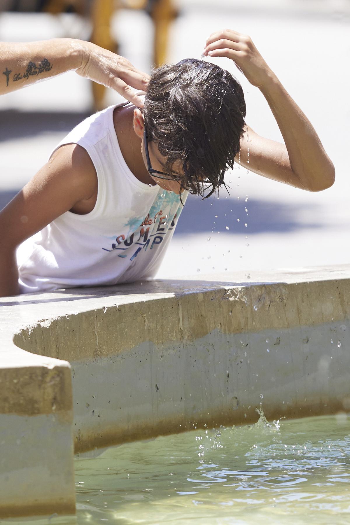 Un niño se echa agua por la cabeza para refrescarse en el primer día de la segunda ola de calor, a 7 de julio de 2022 en Sevilla (Andalucía, España)