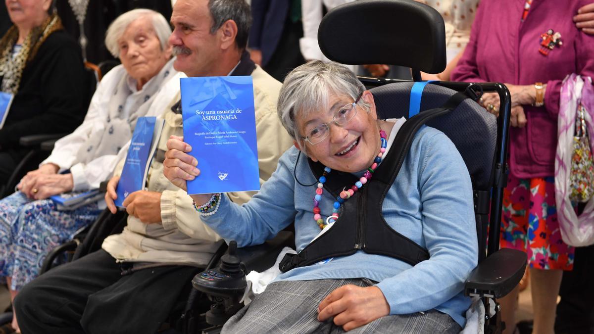 Evelyn Anderson, usuaria de Aspronaga, muy sonriente con el libro de su vida.