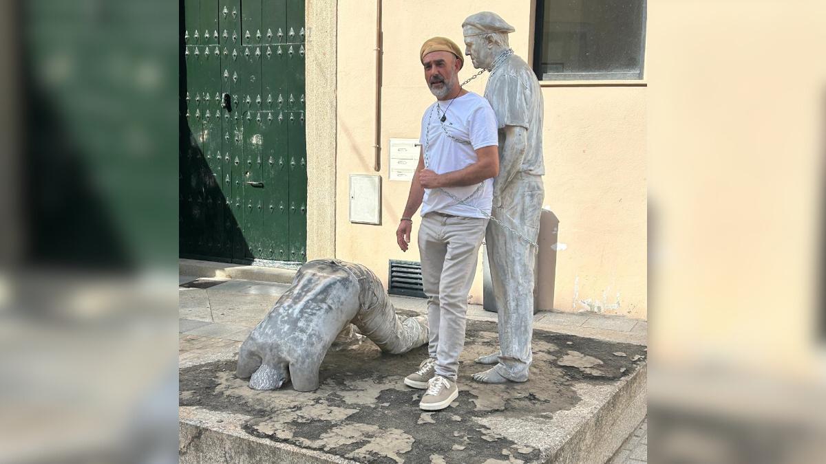 El escultor Antonio Morán, encadenado a una escultura suya en Plasencia.