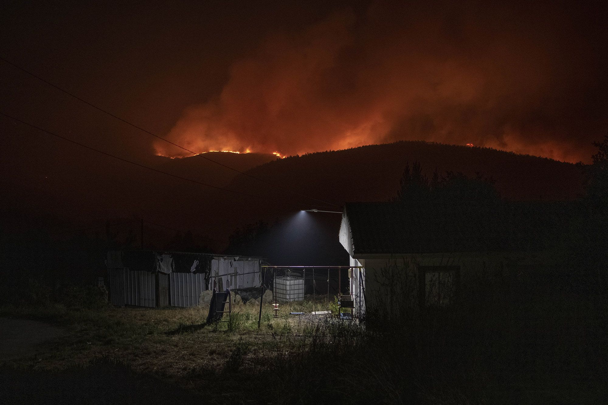 Vecinos y agentes durante la noche del miércoles al jueves, en el incendio de O Irixo, Dozón y Lalín