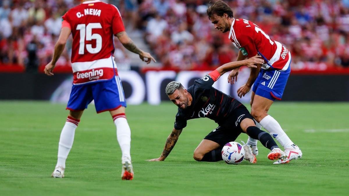 Dani Rodríguez protege el balón en el suelo ante la presión de Ignasi Miquel, del Granada.