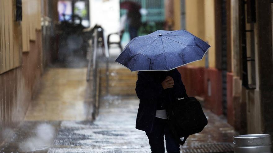 Persona protegiéndose de la lluvia con un paraguas.
