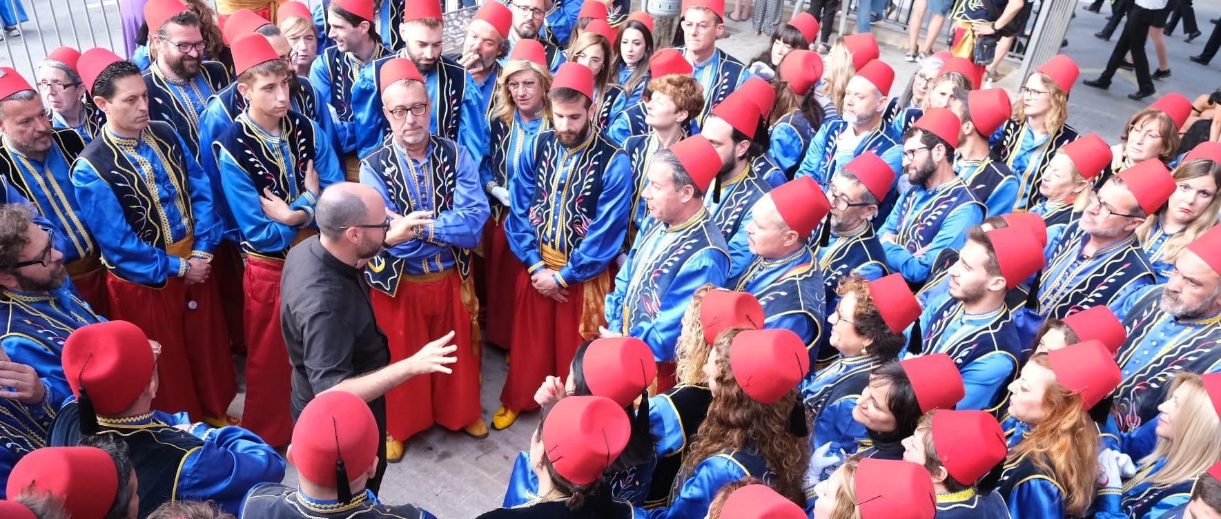 Los porteadores de San Antón recibiendo las instrucciones y la bendición del cura.