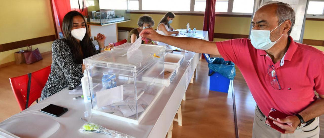 Un elector introduce su papeleta en una de las mesas electorales. // G. Santos