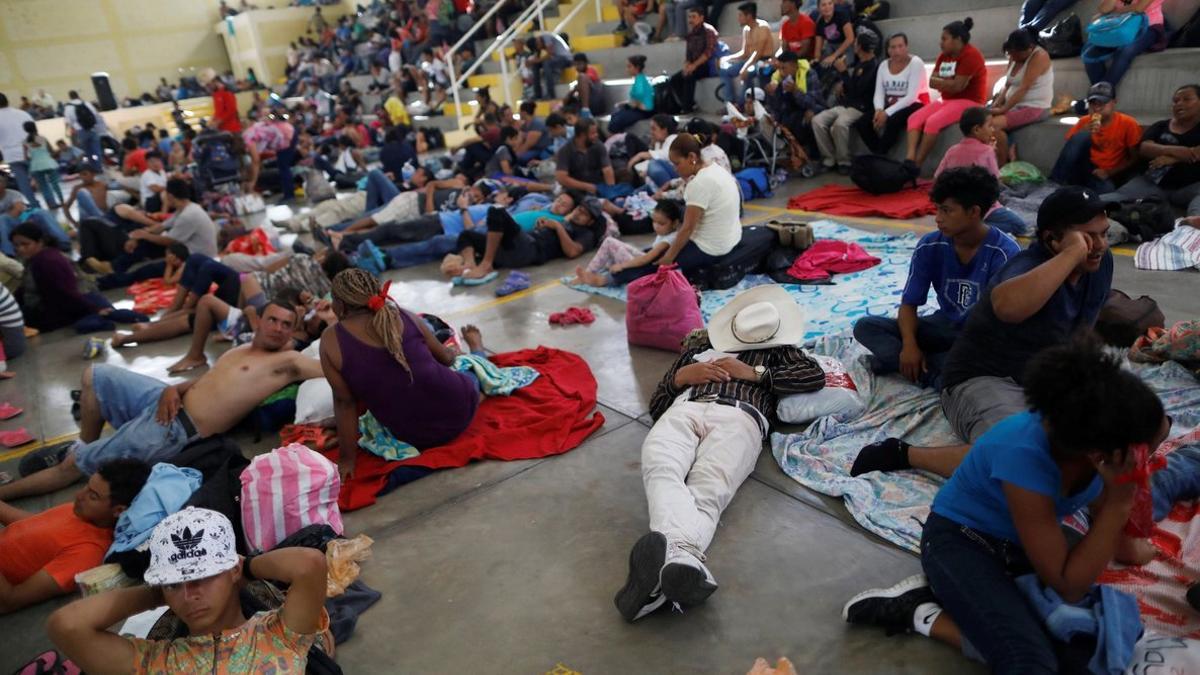 Migrantes hondureños descansan en un refugio