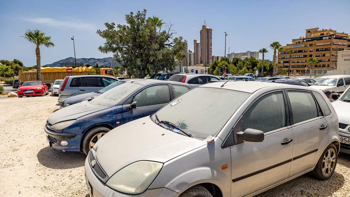 Coches aparcados en el parking público de la avenida Beniardà con avisos en el parabrisas.