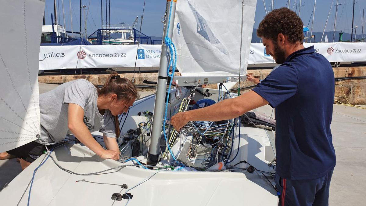 Rodríguez y Mas preparan el barco antes de salir a navegar.