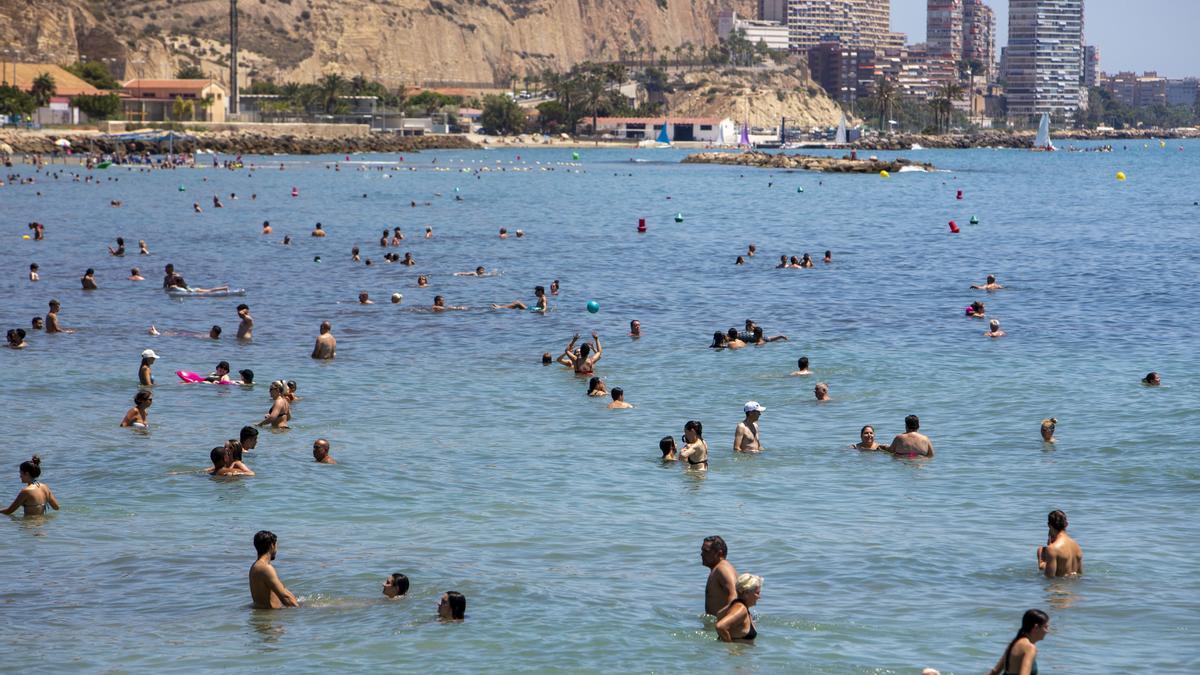 Bañistas tratando de combatir el calor en la playa del Postiguet.