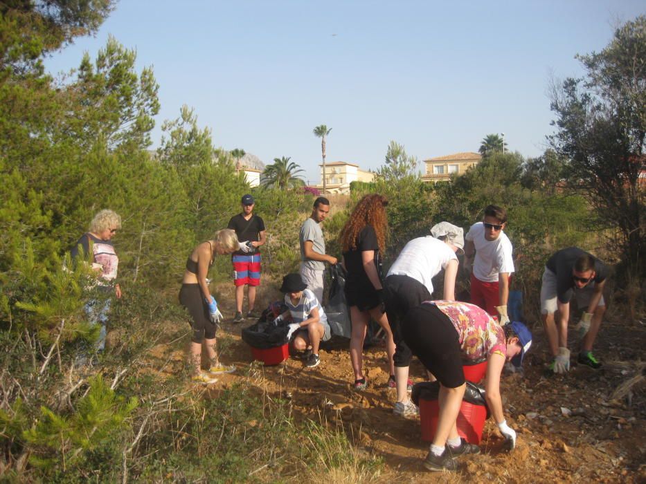 Un grupo de voluntarios de la asociación De Amiticia ha recogido 22 bolsas de vidrio de les Salines