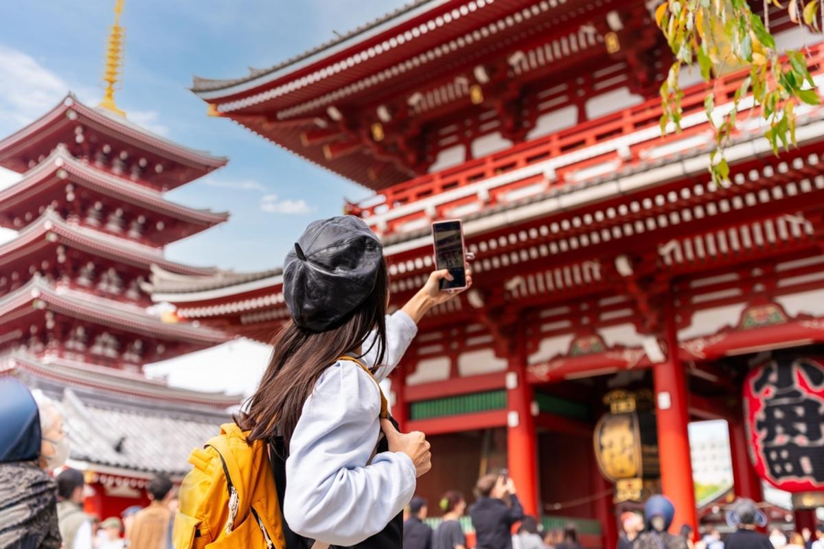 Joven turista tomando una foto del templo sensoji en el distrito de Asakusa en Tokio, Japón
