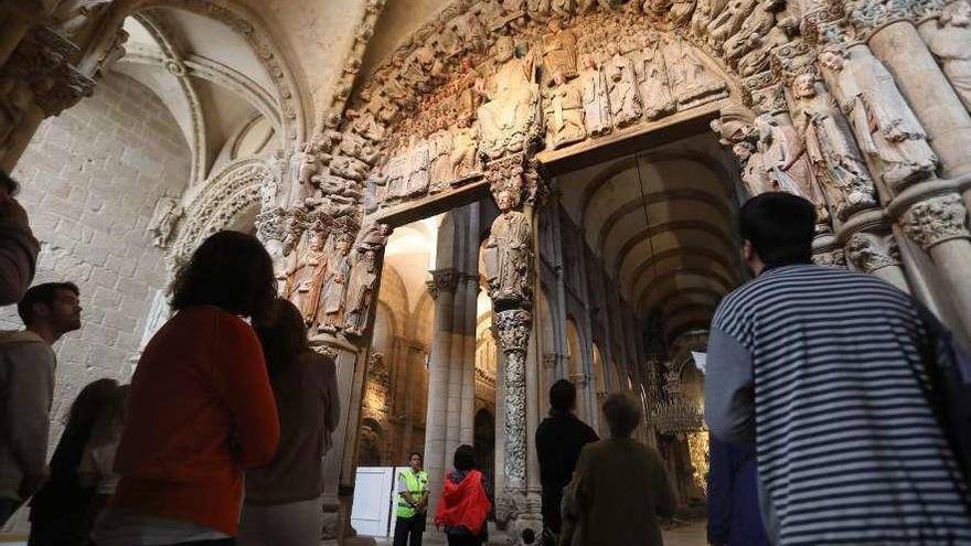 Visitantes contemplan el Pórtico de la Gloria, en la catedral de Santiago.