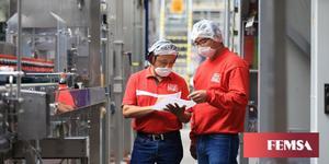 Archivo - Dos trabajadores de Coca-Cola Femsa