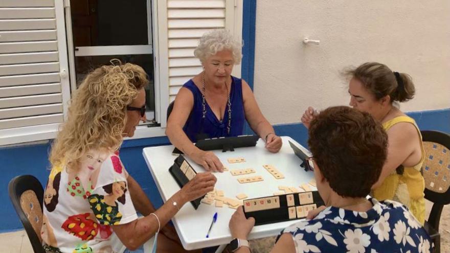 Agustina, de cara, y las vecinas de Tabarca juegan al Rummikub por la tarde cuando la mayoría de turistas han regresado a tierra