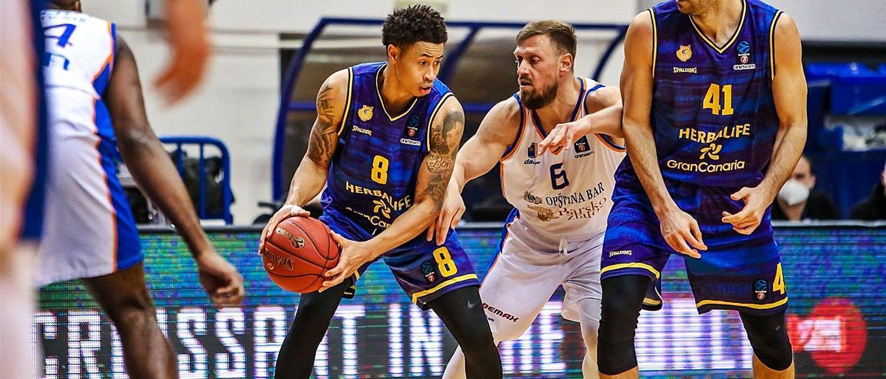 AJ Slaughter –8– mantiene el balón ante la defensa de Marko Jeremic –6–, mientras Oliver Stevic le pone un bloqueo en el duelo del Granca ante el Mornar el martes.  | | EUROCUP