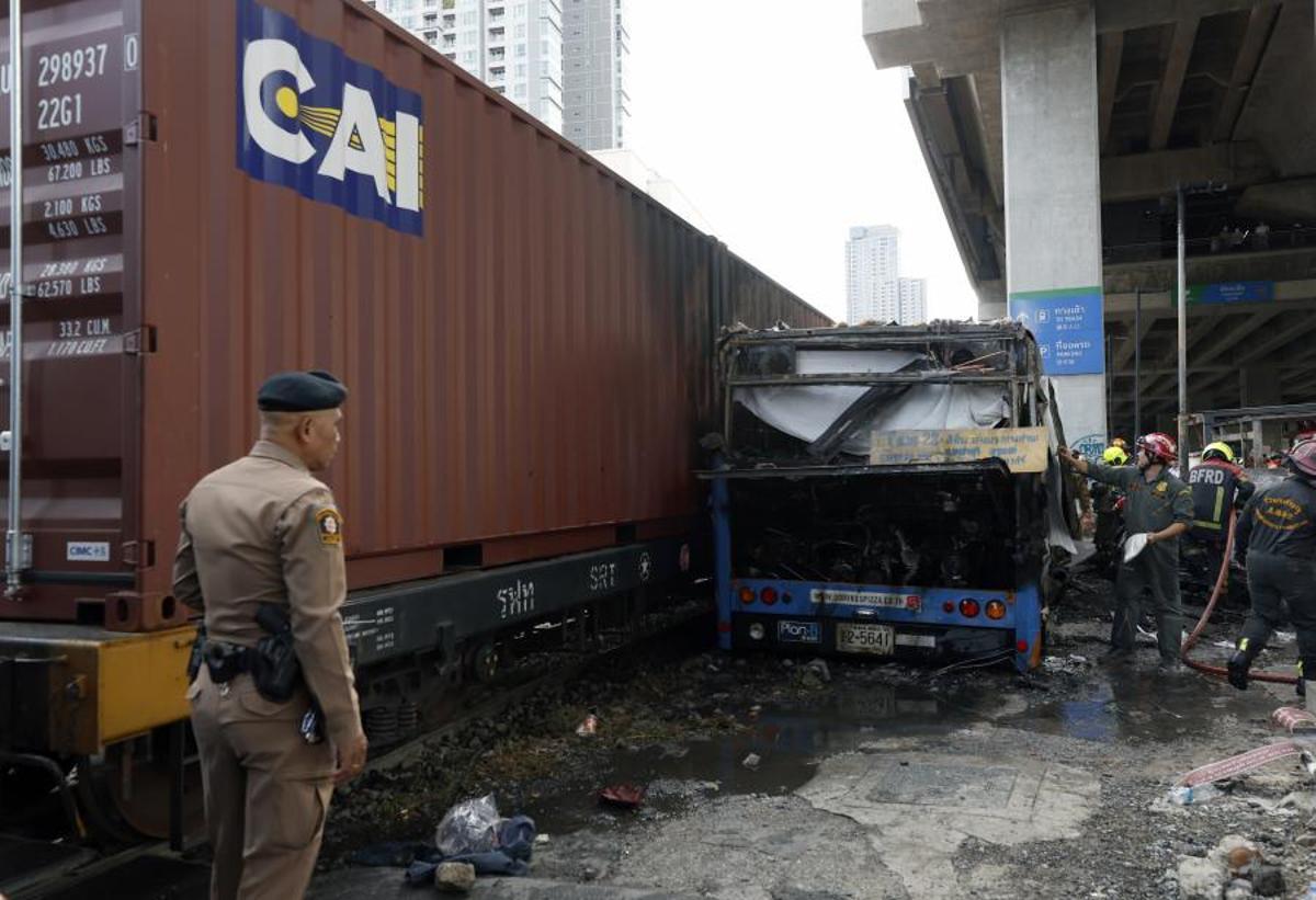 Imágenes del accidente entre un tren y un autobús en Bangkok, que ha dejado al menos ocho muertos y 25 heridos después de que el vehículo se incendiara tras el impacto.