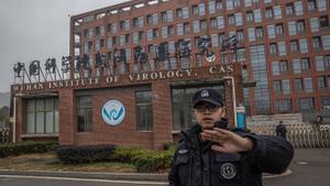 Un guardia de seguridad impide a los fotógrafos acercarse al Instituto de Virología de Wuhan.