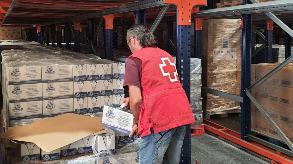 Voluntario de Cruz Roja prepara cajas de alimentos para repartir