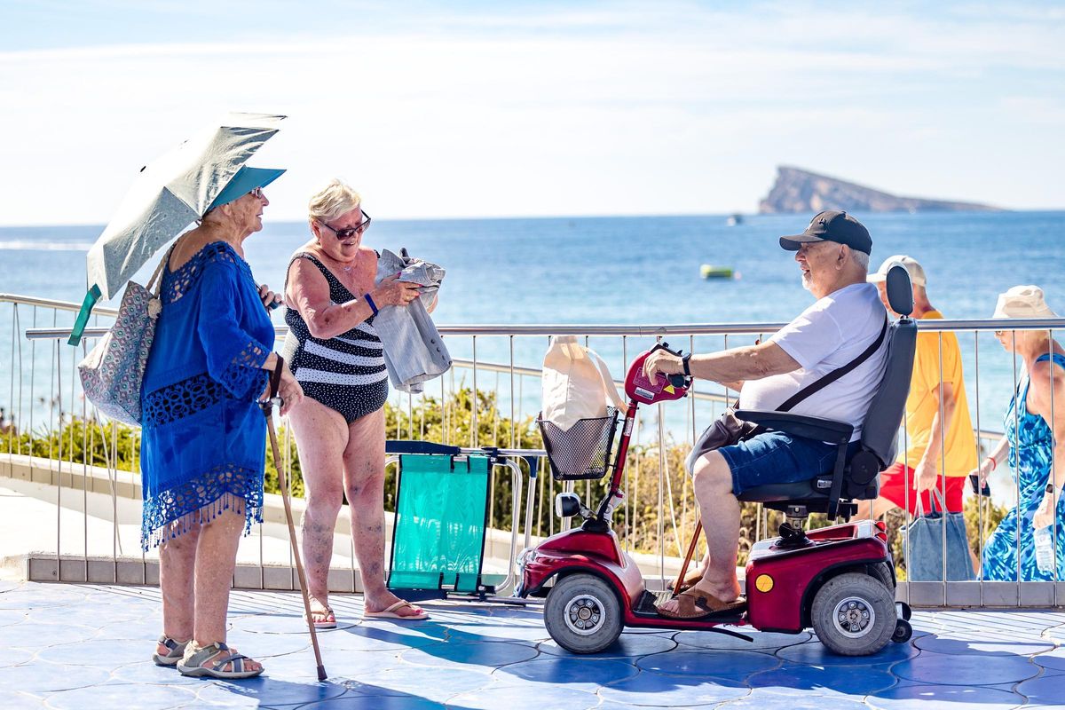 Personas mayores en una paseo cerca del mar en Benidorm.
