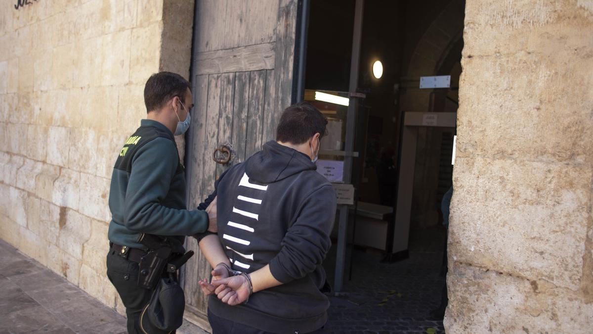 Un detenido ingresa en los juzgados de Xàtiva escoltado por un guardia civil.