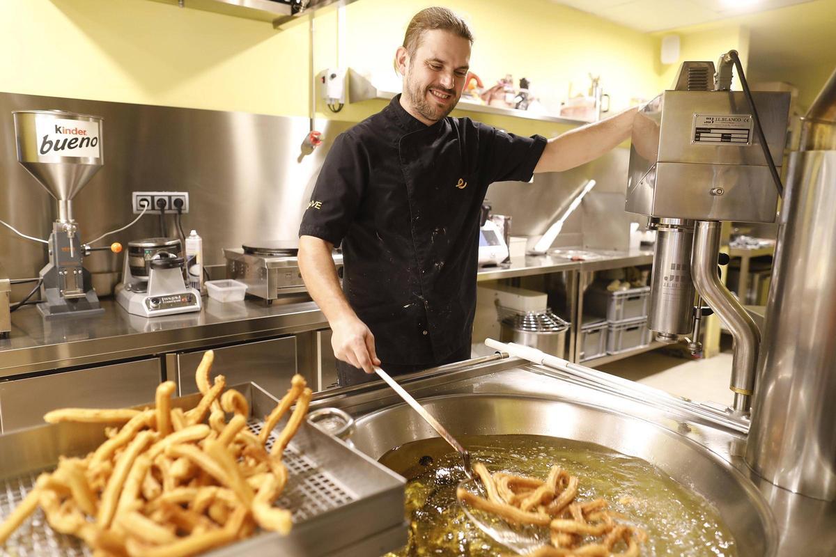 Marc Olivé preparant una pila de xurros en el seu local de Girona.