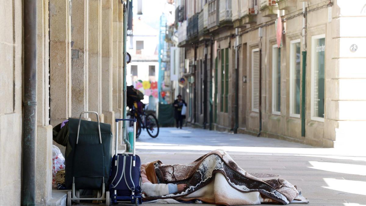 Una persona sin hogar, en los soportales de la plaza de A Ferrería.