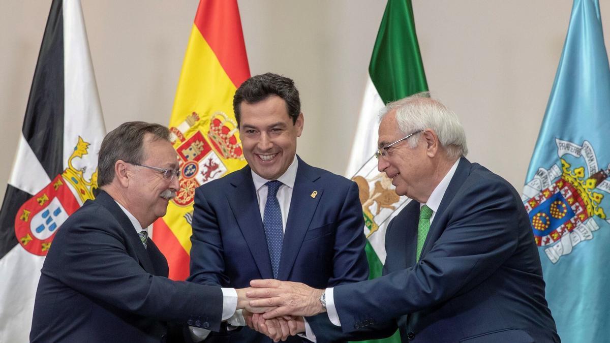 El presidente de la Junta de Andalucía, Juanma Moreno (c), y los presidentes de las ciudades autónomas de Ceuta, Juan Jesús Vivas (i), y Melilla, Juan José Imbroda (d), juntan sus manos tras firmar hoy en el Palacio de San Telmo, en un acto institucional en 2019.