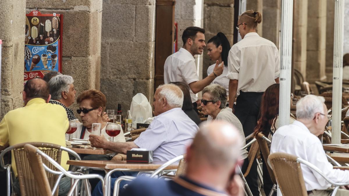 Dos camareros en una de las terrazas de la Plaza Mayor de Cáceres.