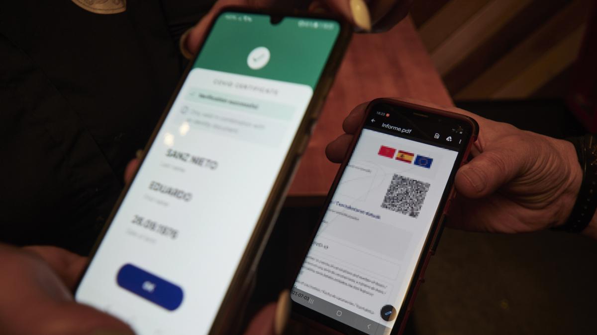 Una persona muestra su certificado COVID.