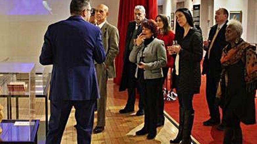 Alberto Martín, de espaldas, explica la muestra a las autoridades asistentes a la inauguración.