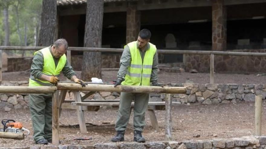 Dos operarios trabajan en el area recreativa del Sant Esperit de Gilet.