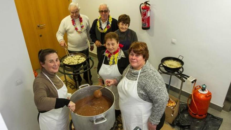 Los voluntarios de la comisión de fiestas de Puig d´en Valls preparan chocolate caliente y churros para repartir entre los vecinos. Se sirvieron unas 400 raciones.