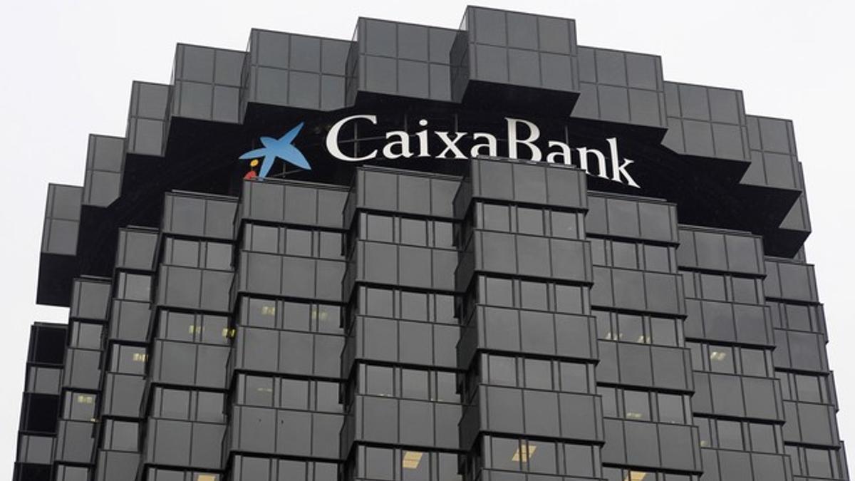 El logo de CaixaBank, en lo alto de la sede central de la entidad, en Barcelona.