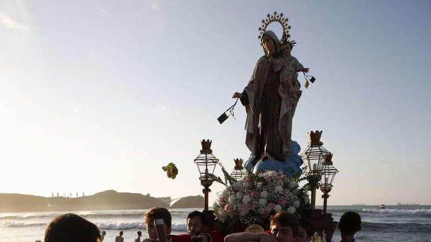 Un grupo de jóvenes introduce a la Virgen del Carmen en el mar, en la playa de Salinas, el 16 de julio del año pasado.