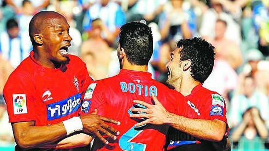 Gregory, Barral y Botía, de espaldas, celebran el gol del Sporting en La Rosaleda. / efe