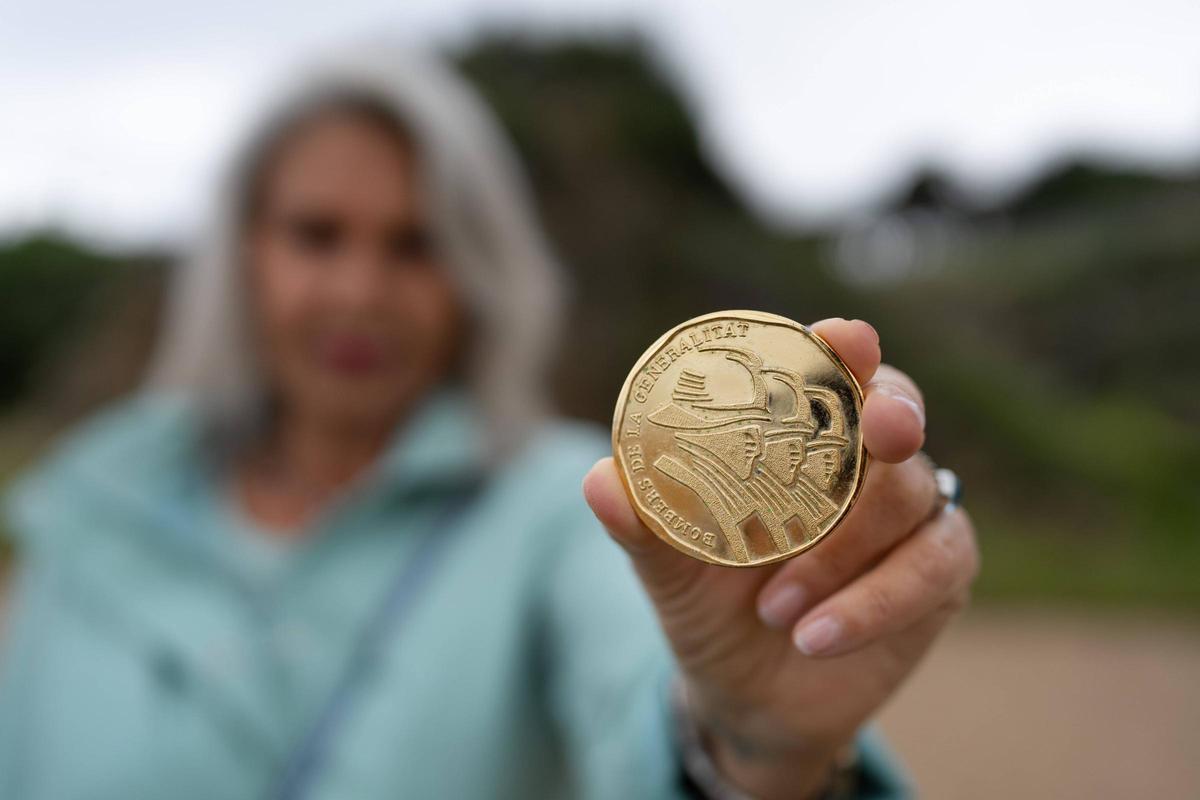 Retratos a Cecília quien muestra la medalla de homenaje por ser 30 años bombera jubilada
