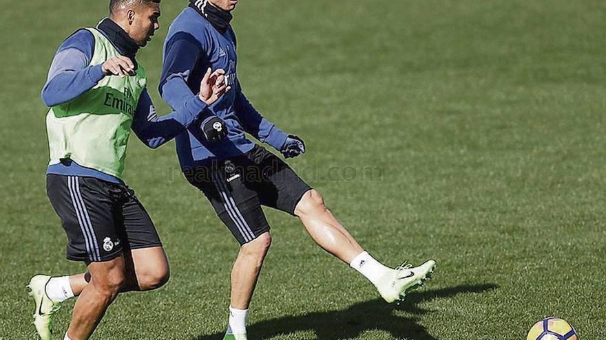 Cristiano Ronaldo golpea el balón ante Casemiro, en el entrenamiento de ayer. // Real Madrid