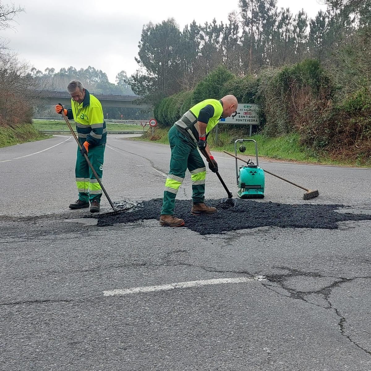 Trabajadores de la brigada de Obras de Ames bacheando una carretera.