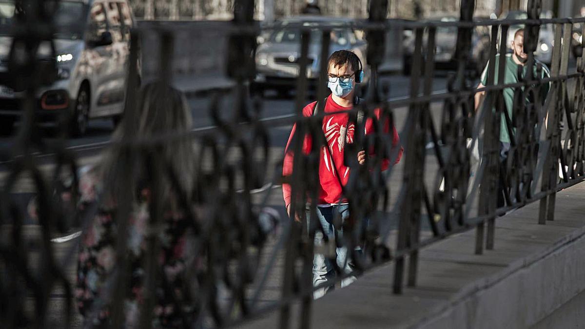 Un joven pasea por Santa Cruz con la mascarilla para evitar contagios.