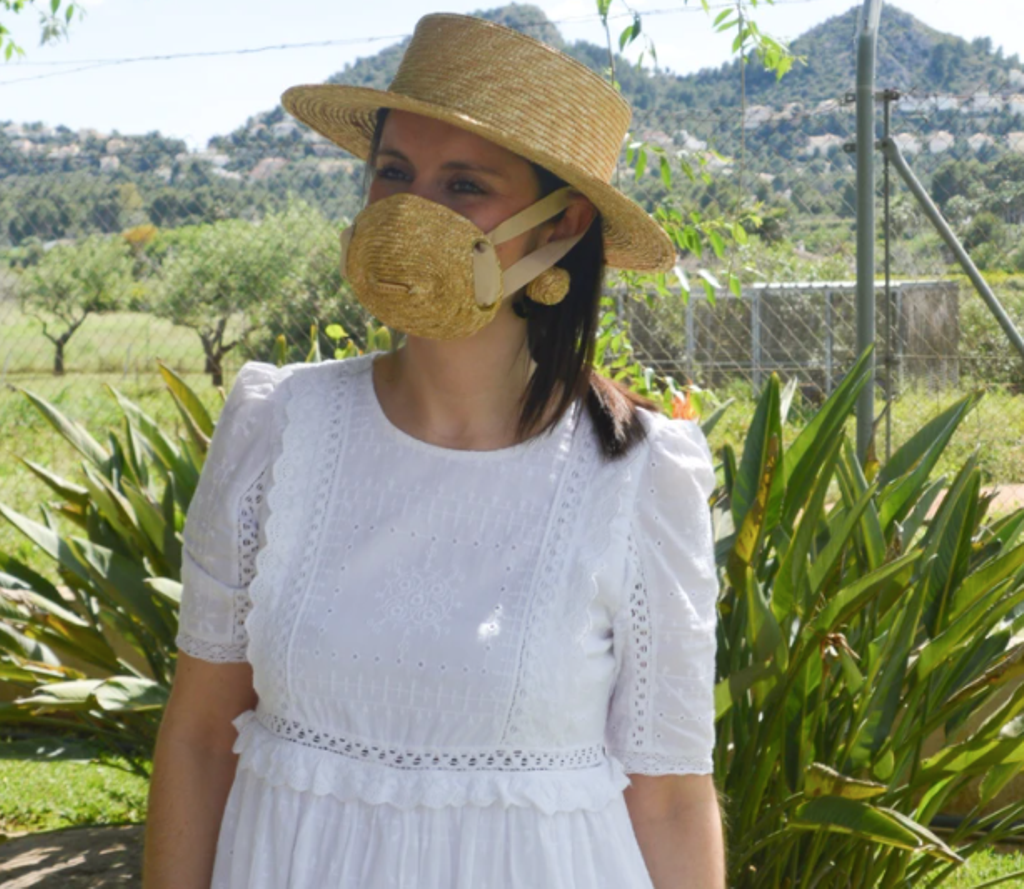 Mujer con mascarilla y gorro de paja