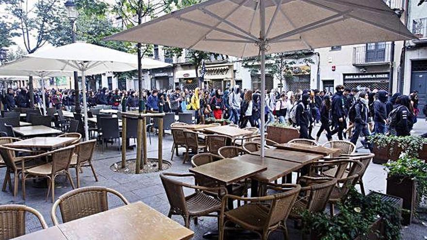 Els manifestants passant per la Rambla de la Llibertat, amb bona part dels comerços tancats.