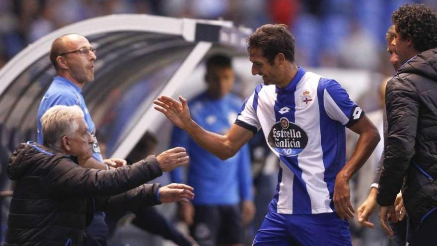 Celso Borges saluda a Juan Hermida en el banquillo deportivista después de anotar su gol.